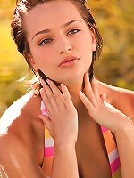 Hailee Rain lays on the rocks by the water