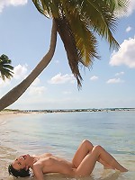 Sexy Liz Valery shows tits and pussy on the palm tree and on the beach